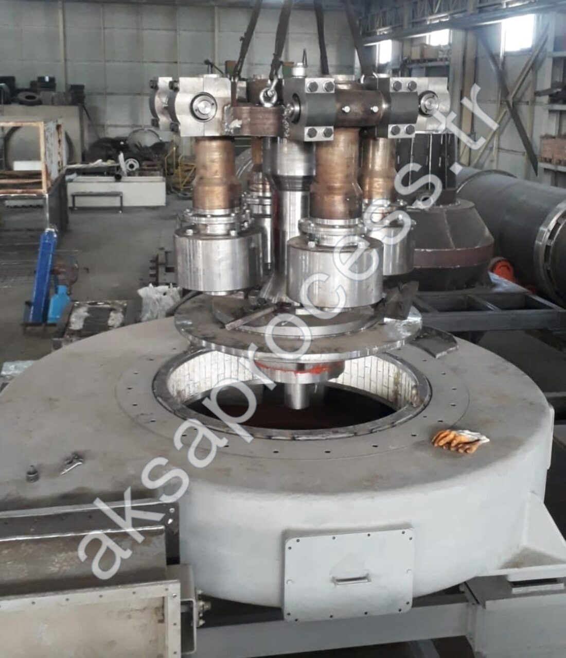 Pendulum roller assembly being lowered into the grinding chamber in our workshop: four pendulum rollers with their journals, mechanical seal housings, and grinding-ring liner